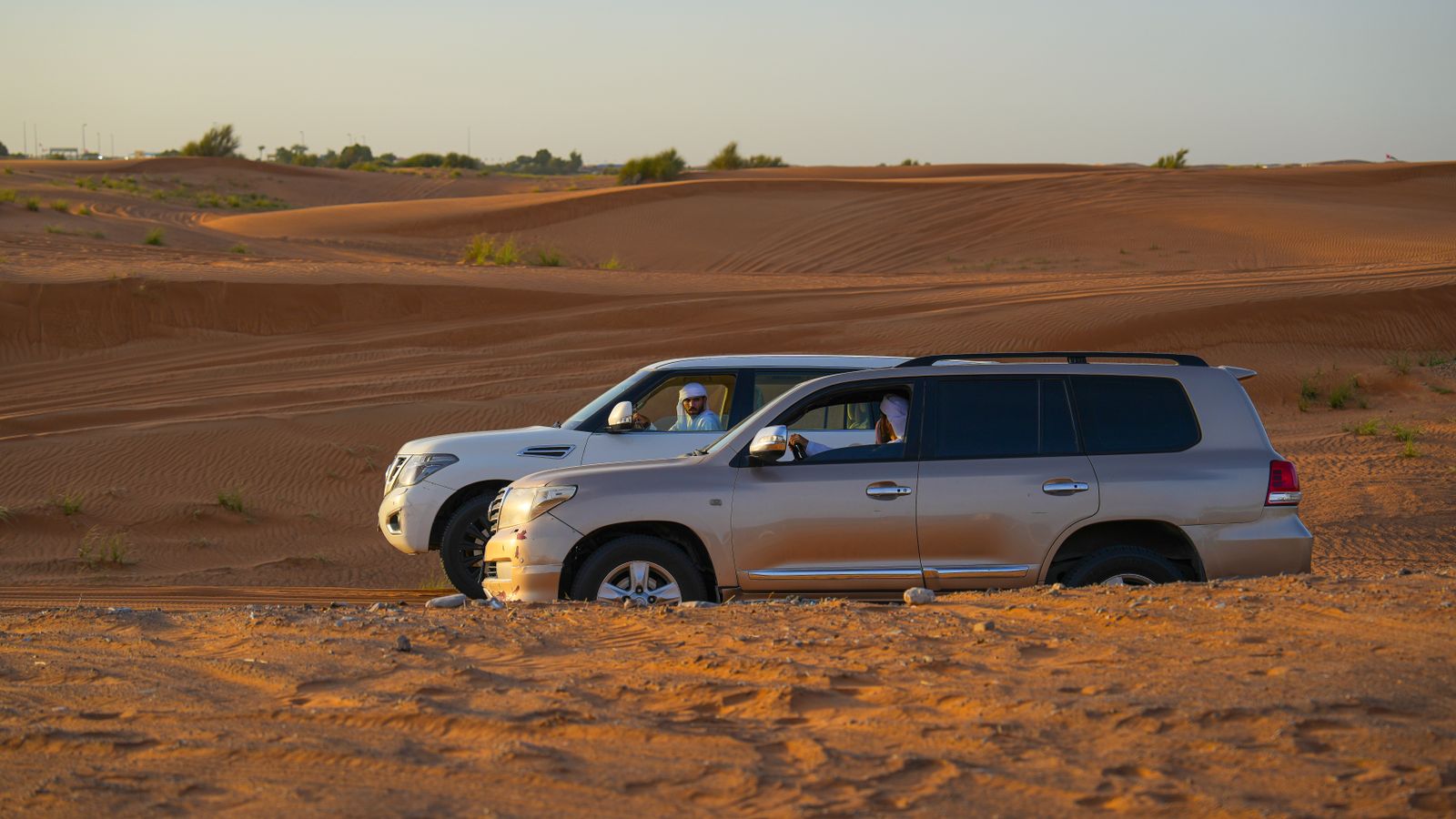 SUVs driving on a sandy desert road