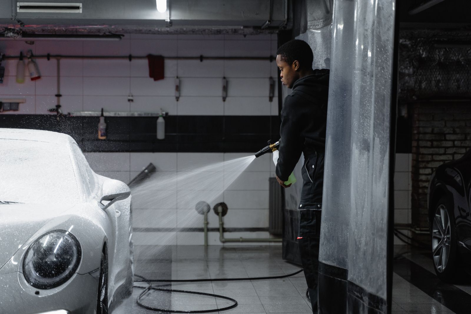 Crew member cleaning a car headlight